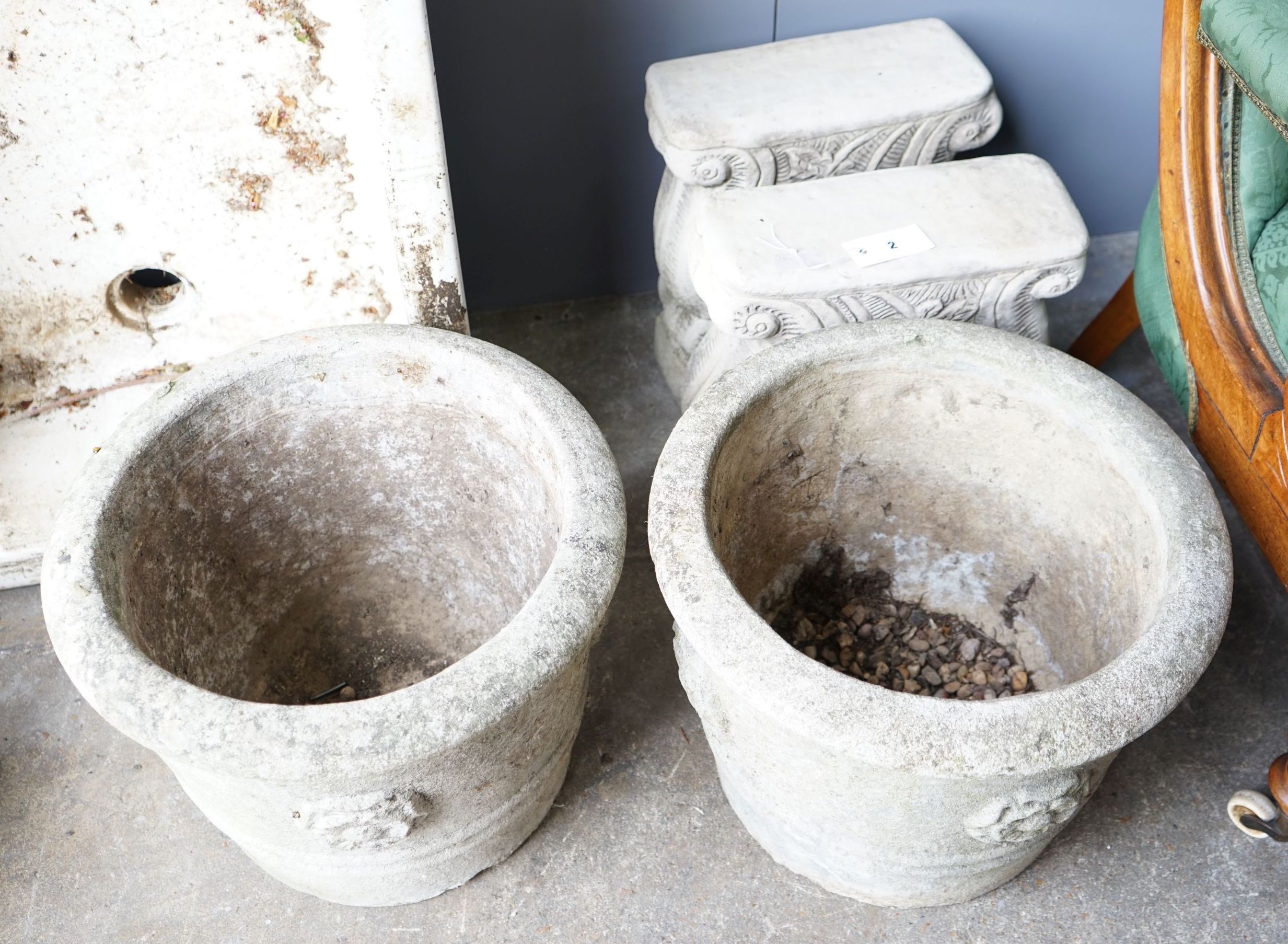 A pair of circular reconstituted stone garden planters, diameter 42cm together with a pair of stone bench supports